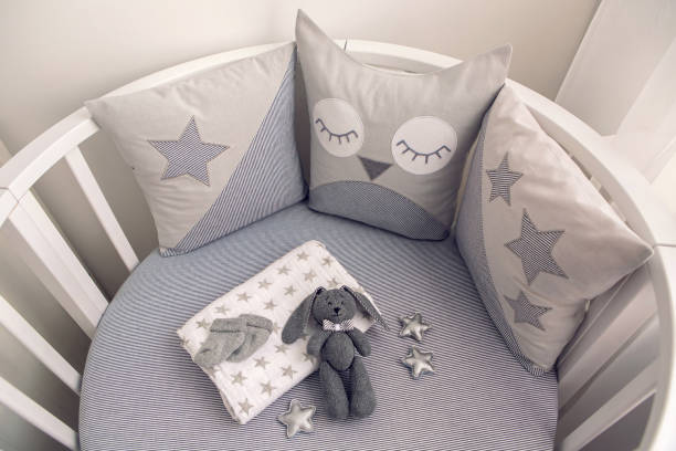 istock round white baby bed with gray pillows 643553922