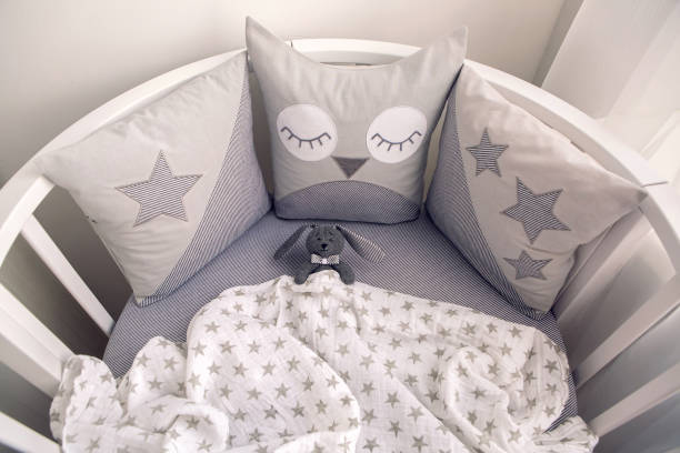istock round white baby bed with gray pillows 643553994