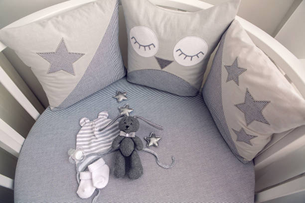 istock round white baby bed with gray pillows 643554160