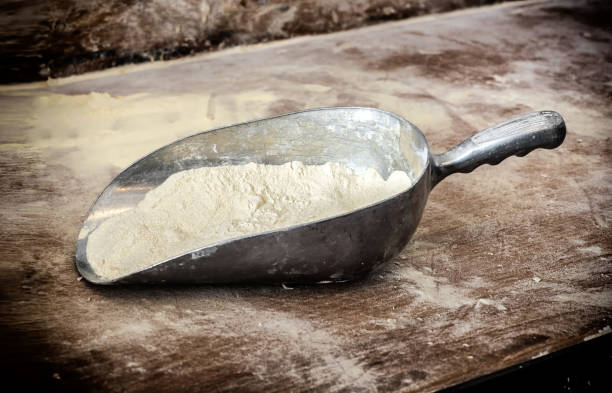 istock Scoop of flour on wooden table 643557850