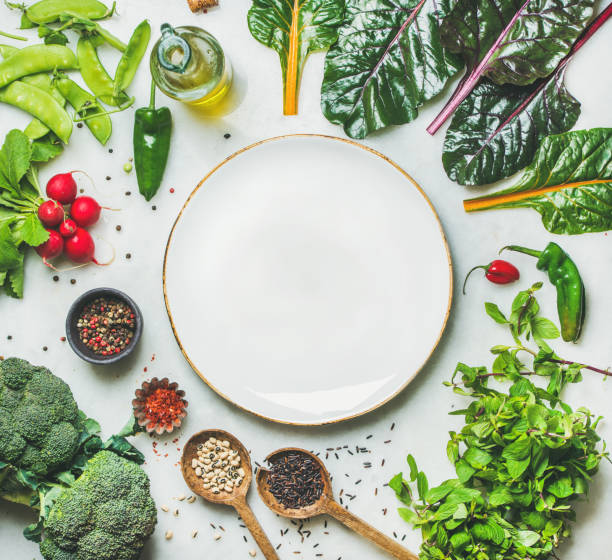 istock Fresh greens, raw vegetables and grains, white plate in center 643563800