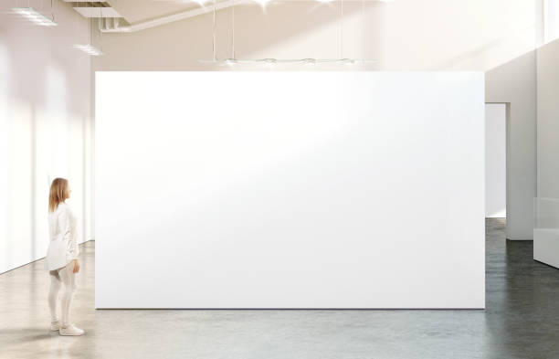 istock Woman walking near blank white wall mockup in modern gallery 643567018