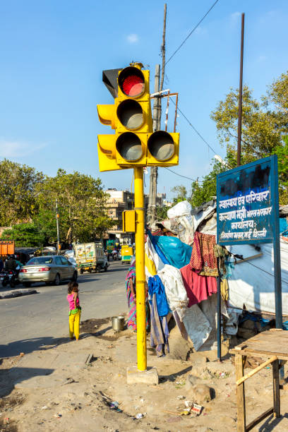 street scene with people and traffic light in  Delhi street scene with people and traffic light in the poor area of New Delhi, India. old delhi stock pictures, royalty-free photos & images