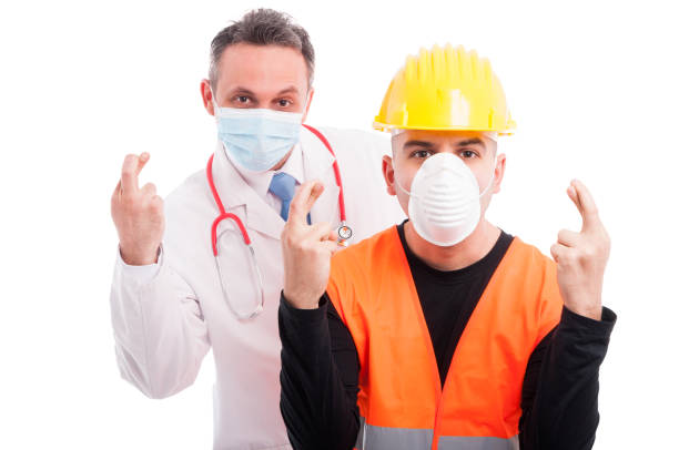 istock Doctor and constructor showing fingers crossed gesture 643578462