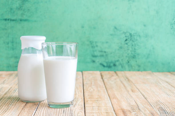 istock milk on a wooden table on Green background 643579388