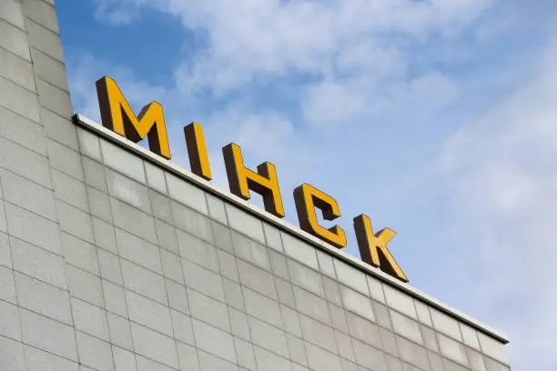 A sign with the name of the city of Minsk at the railway station building in the Belarusian language. The capital of Belarus. Yellow letters on a background of blue sky.