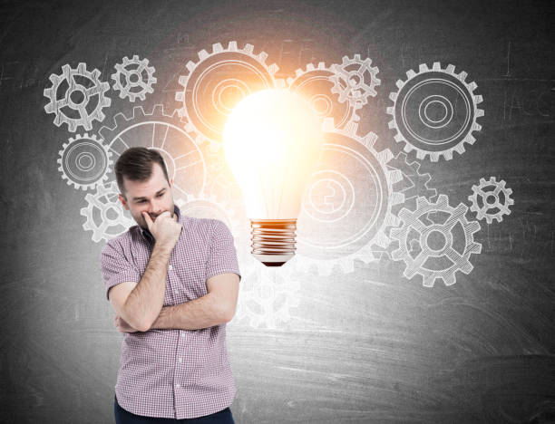 istock Man in pink shirt, cogs and light bulb 643582486