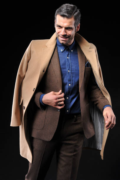 istock Businessman posing with suite on black background 643598578