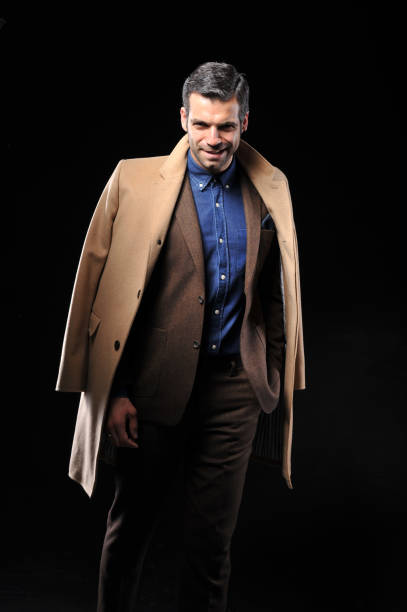 istock Businessman posing with suite on black background 643598634