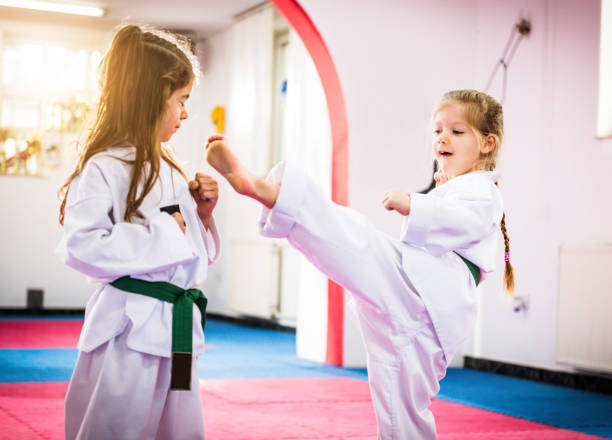 istock Two cute girls on taekwondo training, kicking and learning self-defence 643598660