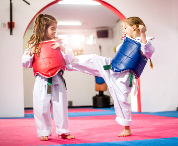 istock Two cute girls on taekwondo training, kicking and learning self-defence 643601248