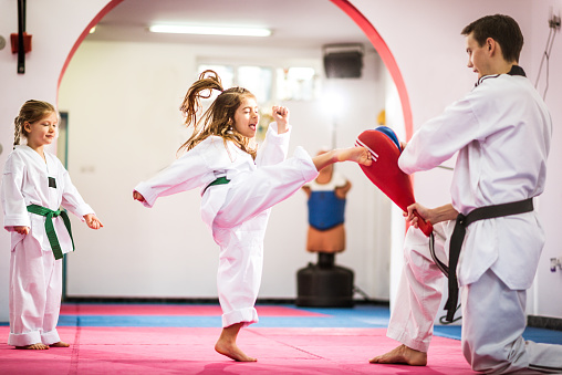 Dos chicas lindas en taekwondo entrenamiento, patadas y aprender autodefensa photo