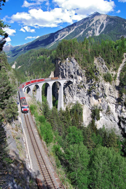 Trein van de RhB op het Landwasserviaduct Trein van de Rhätische Bahn  onderweg van St. Moritz naar Chur. De trein heeft zojuist het beroemde Landwasserviaduct gepasseerd graubunden canton stock pictures, royalty-free photos & images