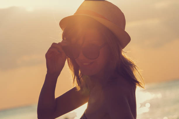 istock Cute smiley girl enjoying the ocean and sunset. 643619632