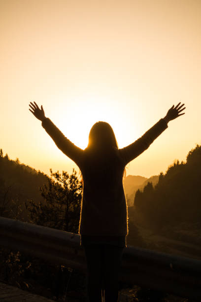 istock Woman open arms at sunrise 643620680