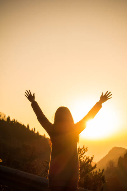 istock Woman open arms at sunrise 643620750