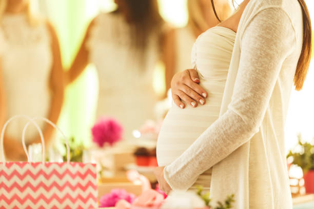 mujer embarazada en baby shower - baby shower women home interior indoors fotografías e imágenes de stock