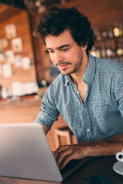 istock Attractive man using a laptop at the cafe 643625526