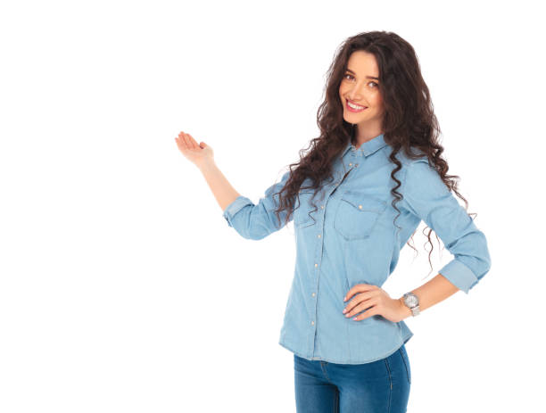 istock smiling young casual woman presenting 643632850