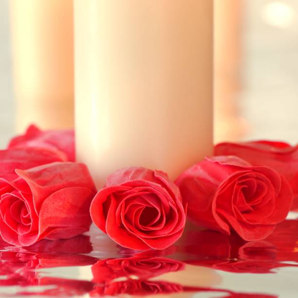 istock Red soap roses with reflection positioned in a circle around a candle 643650682