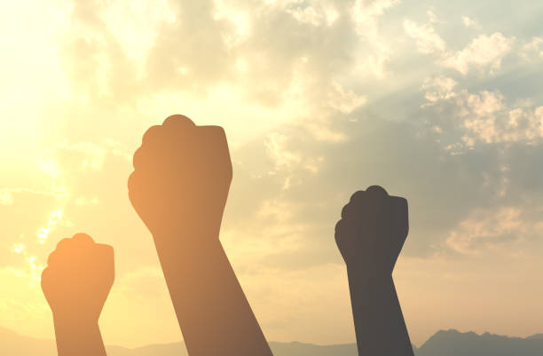 istock silhouette hands fist with sun lighting 643654508