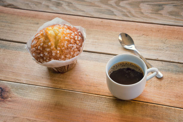 Cup of coffee and muffin on a rustic wooden table