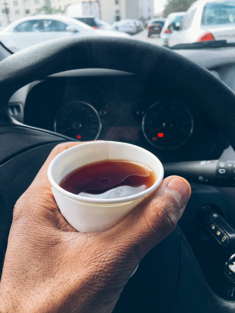 istock Man hold hot tea paper cup in car. 643665842
