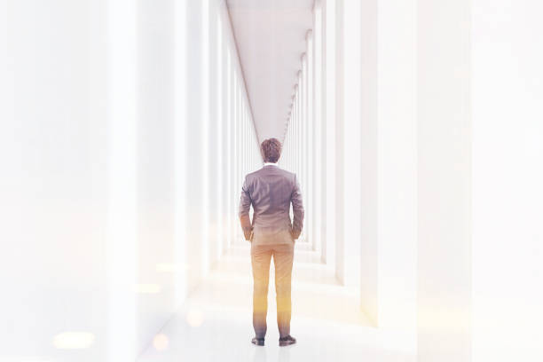 istock Rear view of a man in a white corridor, toned 643679128
