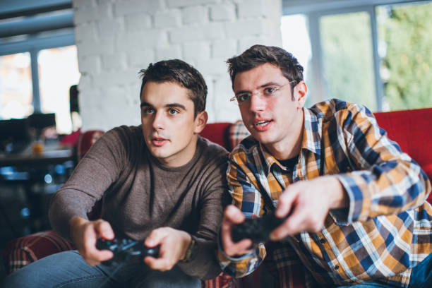 istock Closeup of two friends playing video game 643683118