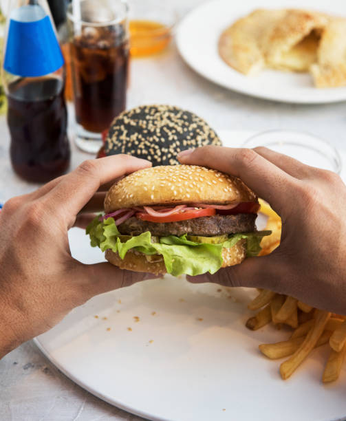 istock Man eating burgers 643685604