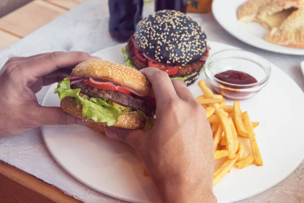 istock Man eating burgers 643685742