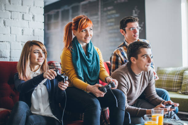 Group of young happy friends playing video games at home.