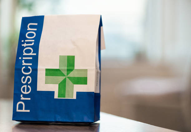 Prescription medicine in a paper bag A close-up image of a paper bag containing prescribed medical items. prescription medicine photos stock pictures, royalty-free photos & images