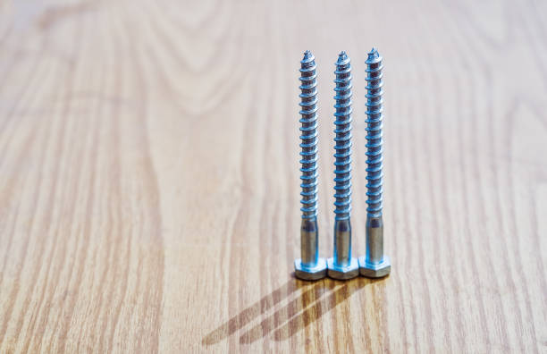 istock Three metal screws on a wooden surface 643710870
