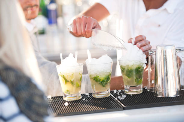 Making mojito Unrecognizable bartender making mojito cocktail bar busy stock pictures, royalty-free photos & images