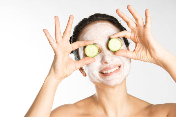 kobieta trzymająca ogórek nad oczami - cucumber human eye spa treatment health spa zdjęcia i obrazy z banku zdjęć