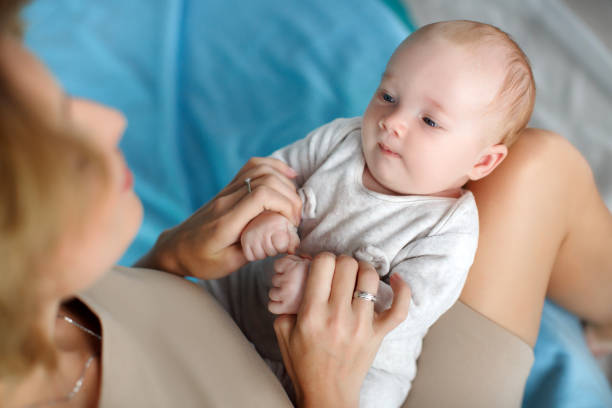 istock Mother plays with the baby,putting him on her knees 643722316