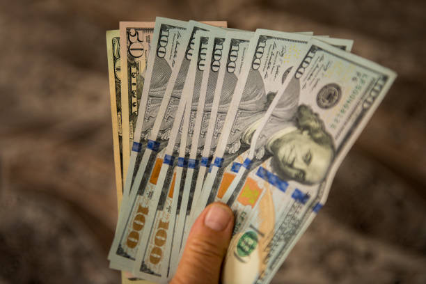 istock High angle view of unrecognizable person holding US Dollar bills 643734242