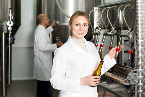 istock Smiling female brewery worker with bottling machinery 643740876