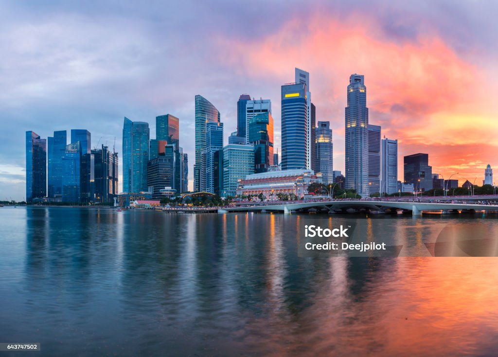 The Singapore Downtown and Marina Bay Business District Skyline at twilight with sunset illuminating the clouds and sky The Singapore Downtown City and Marina Bay Business District Skyline at twilight with reflection in the still water. Singapore Stock Photo