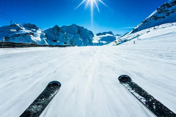 POV of alpine downhill skiing on sunny day.