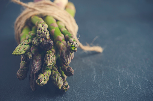 Rustic Asparagus bunch with string. Close up Shot on slate.