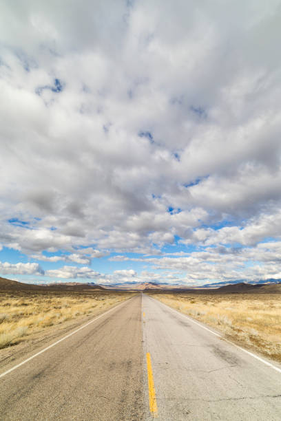 istock Empty rural paved road in the Nevada desert under cloudy skies. 643760254