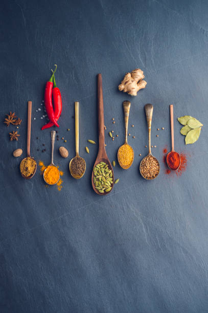 Variety of herbs and spices on slate background. Variety of herbs and spices on slate background. Many are held on metal and wooden spoons. There is also a chilli pepper. mustard photos stock pictures, royalty-free photos & images