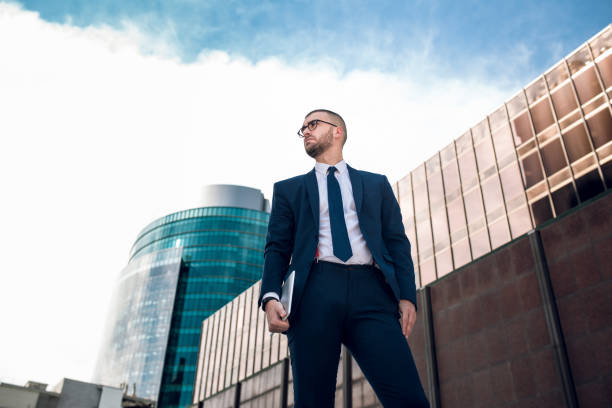 istock young confident businessman standing outdoors 643778606