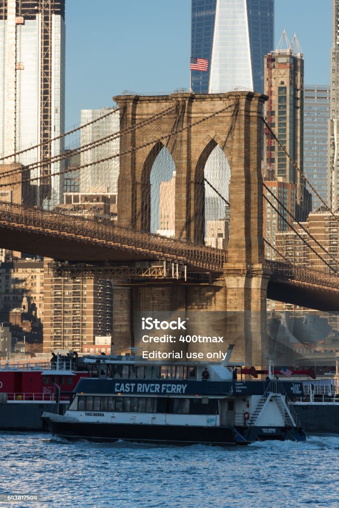 Brooklyn Bridge New York, USA - January 10th, 2016: The Manhattan skyline with the Brooklyn bridge as the East River Ferry passes by late in the day. Arrival Stock Photo
