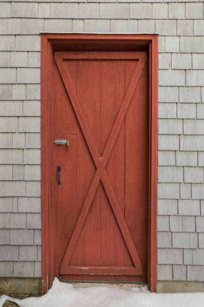 istock Red barn style door on cedar shakes shingles background 643831194
