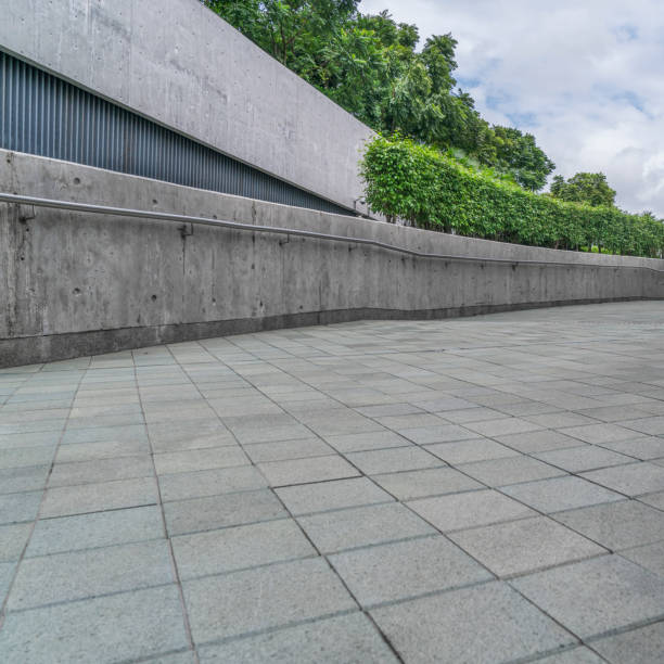 istock perspective view of grey concrete wall with fresh trees 643838732