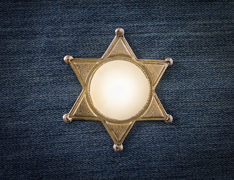 Wild West Sheriff badge on denim background
