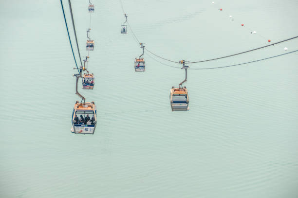 The Ngong Ping 360 is an aerial tramway on Lantau Island in Hong Kong. Photo taken contains the cable cars and passengers en route to the top of Lantau Island in Hong Kong.